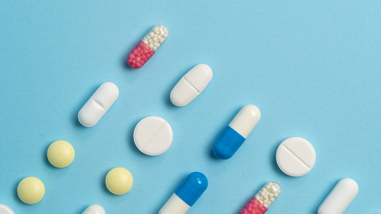 Pills lined up on blue background