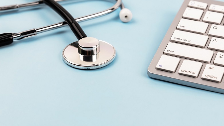 Stethoscope and keyboard on blue background
